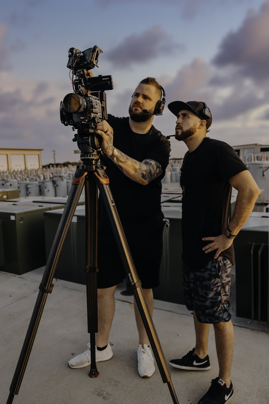 Hyped Visuals crew reviewing footage on a cinema camera during golden hour on location for People's Electric Cooperative