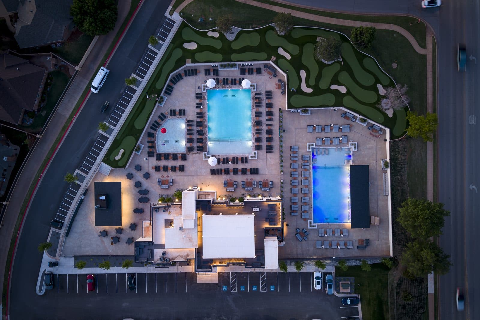 Aerial view of Rose Creek Country Club's pool complex and clubhouse at dusk, Edmond, Oklahoma